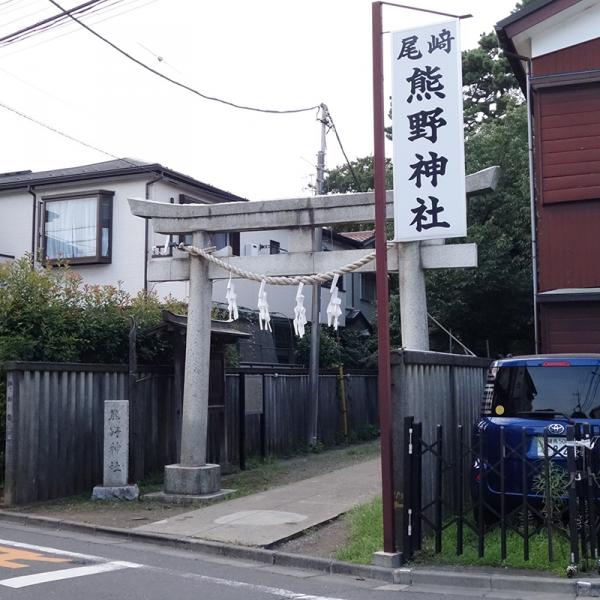 家と家の間に立つ鳥居。その先に参道が続く