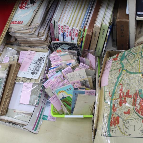 古書だけでなく、古地図や古い絵葉書などさまざまなものが並ぶ