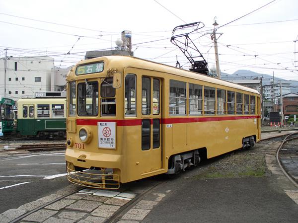 長崎電気軌道701号として第２の人生を歩んでいる杉並線の2000形車両。同社浦上車庫前にて撮影。当時の都電カラーに塗装されている。車体には「私は元東京都電2018号車です」と書いたプレートが掲示されている（写真提供：長崎電気鉄道株式会社）