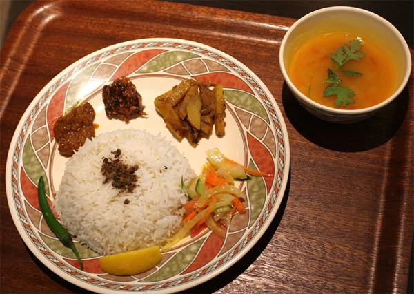 スパイスが香り高い「ボルタバジセット」（1,050円）。総菜は、左から、ボルタ２種類、本日の野菜バジ、バングラデシュ風サラダ。これにマイルドな味の「ひよこ豆スープ」が付く