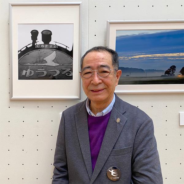 荒川好夫さん。背景左は、荒川さんが1967（昭和42）年３月5日、国鉄・常磐線平機関区で撮影した作品「ゆうづる」