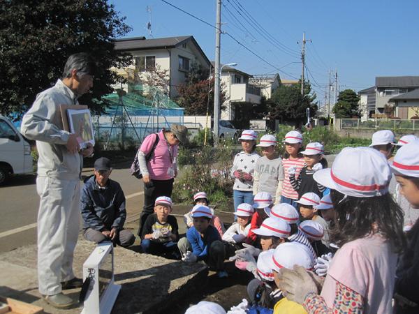 課外授業で農園の見学に来た小学生にミツバチの生態について解説（写真提供：山口朝）