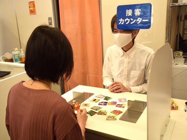 接客カウンターで、その人に合ったボードゲームを提案する丸田さん