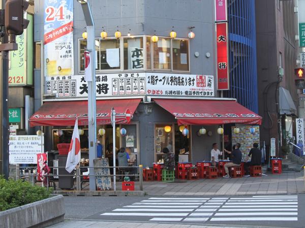 焼き場から煙と香りが立ち込める「大将」本店。夕暮れ時から店先がにぎわっているのは高円寺らしい光景