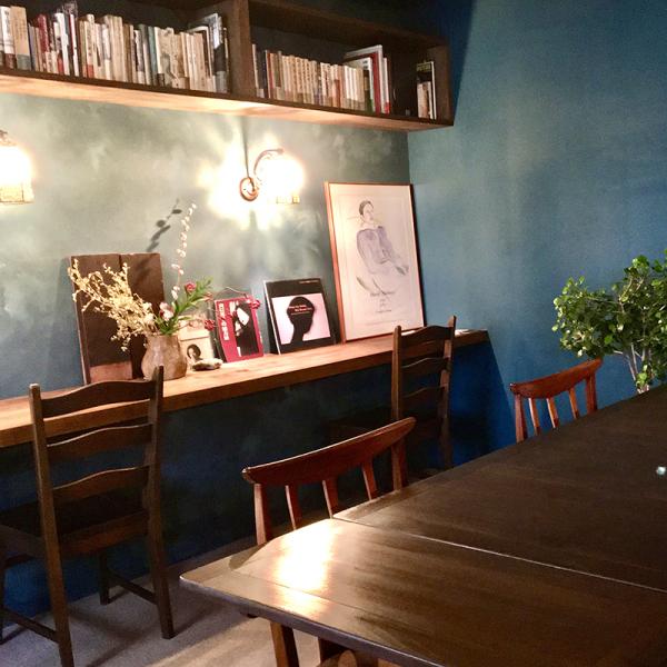 青い壁を温かいオレンジ色の光が照らす、落ち着いた店内。宮澤さんが一からデザインした