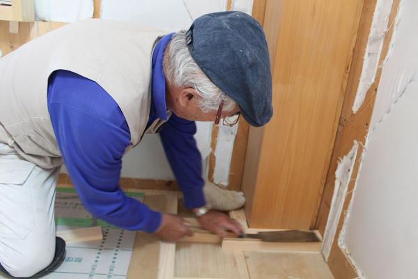 床材を差し込むためミリ単位の調整を行う棟梁の本村さん
