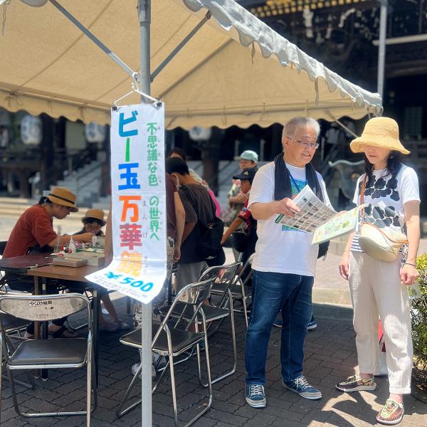 地域イベントでかるたの説明をする荻本さん