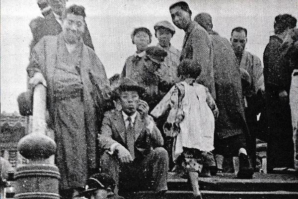 1931（昭和６）年５月、江東区亀戸の太鼓橋にて。座っているのが小林多喜二（出典：『新潮日本文学アルバ ム 小林多喜二』）