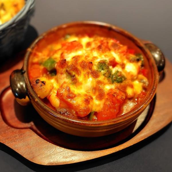 エビと野菜とトマトソースにチーズがかかった熱々のカリデス・ギュヴェチ