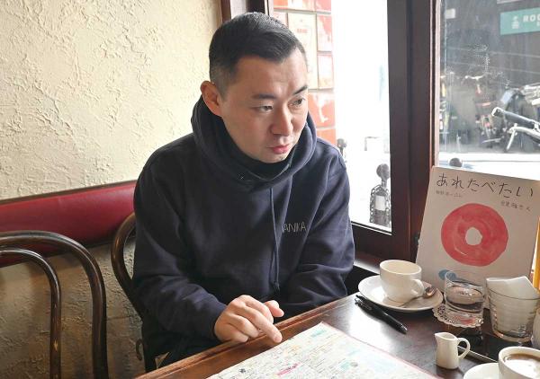 街歩きマップを見ながら思い出の場所を語る。窓辺に置かれているのは、絵を担当した絵本