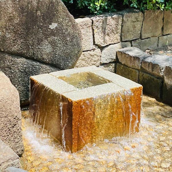 四角い井戸のようなところからじゃぶじゃぶと勢いよく水が流れ出ている