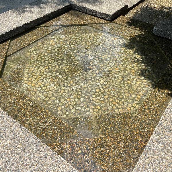 四角いじゃぶじゃぶ池の縁に座って、足を水に浸すこともできる