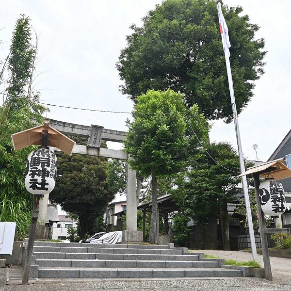 1924（大正13）年建立の鳥居。そばに丸く手入れされたナギの木がそびえる