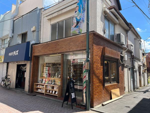 理容店時代の大きなガラス窓とサインポールが残る「本店・本の実験室」