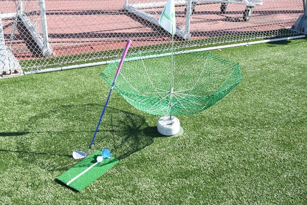 クラブとボール、ゴルフマットと傘のようなホール