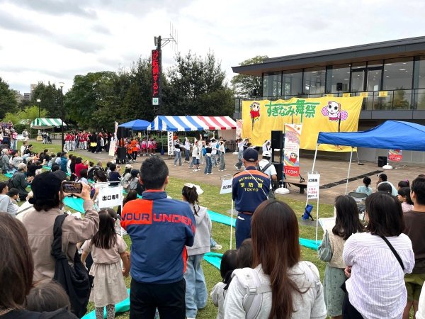 芝生の上でダンスステージを見守る観客