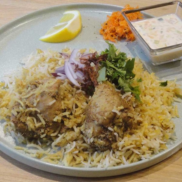 豪快な盛り付けの「チキンビリヤニ」。ライタ（ヨーグルトソース）が付く