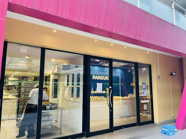 ピンクの外壁が目印。ガラス越しに作業風景が広がり、店内の様子が見える