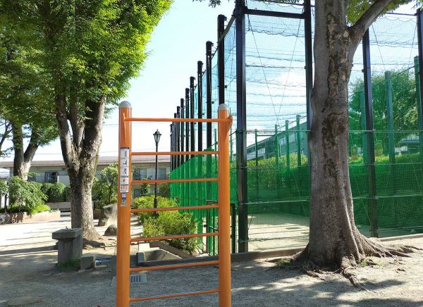 健康遊具と、フェンスで囲まれた球技場