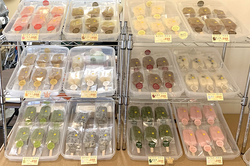 ずらりと並んだ12種類の「ライスキャンディー」（１本250円）。上段左から、いちご、コーヒー、バニラ、チョコ、きなこ、プレーン、あずき、塩豆、抹茶、ごま、よもぎ（一番人気）、さくら